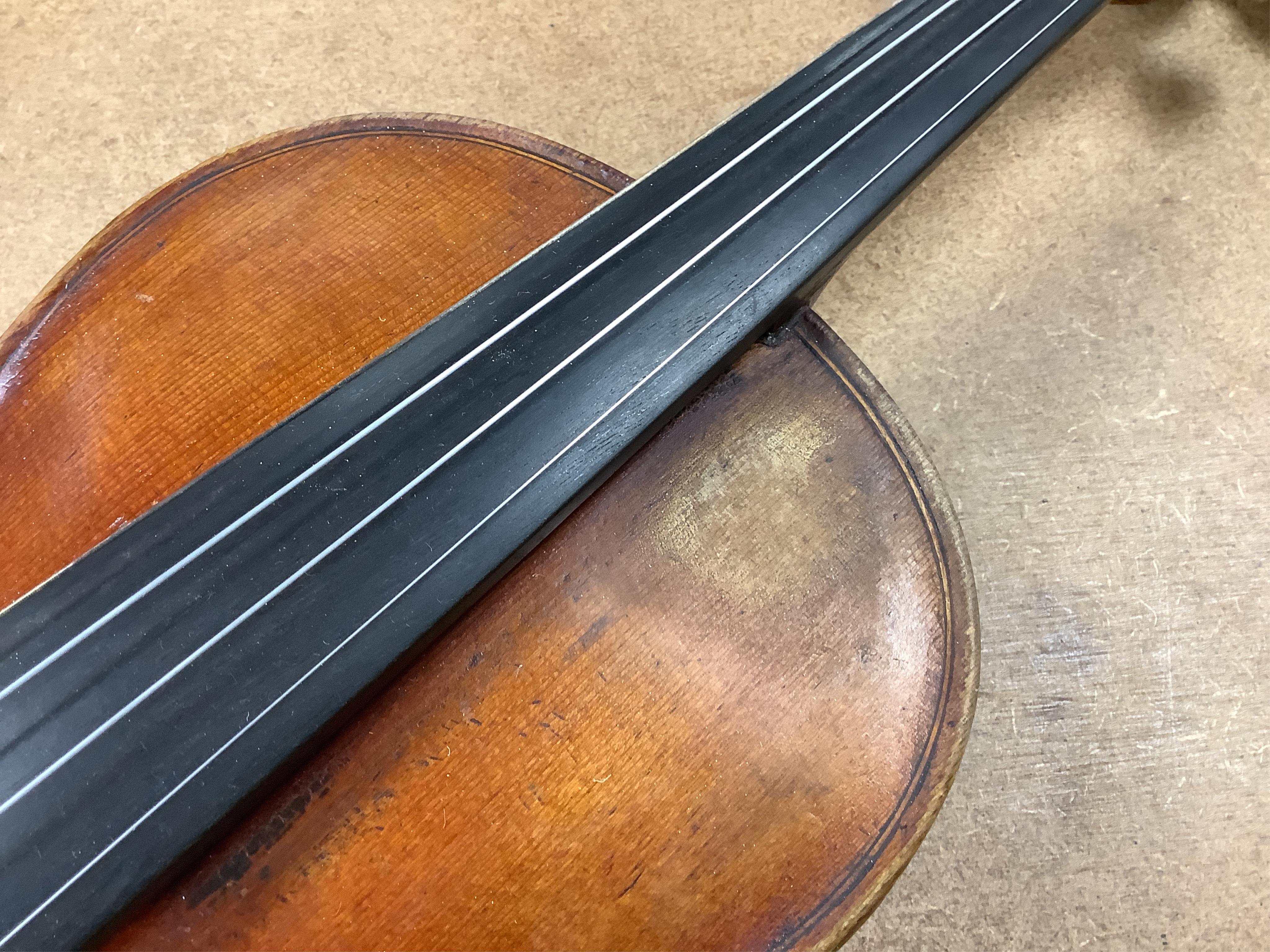 An early 20th century cased violin and cover, 60cm long